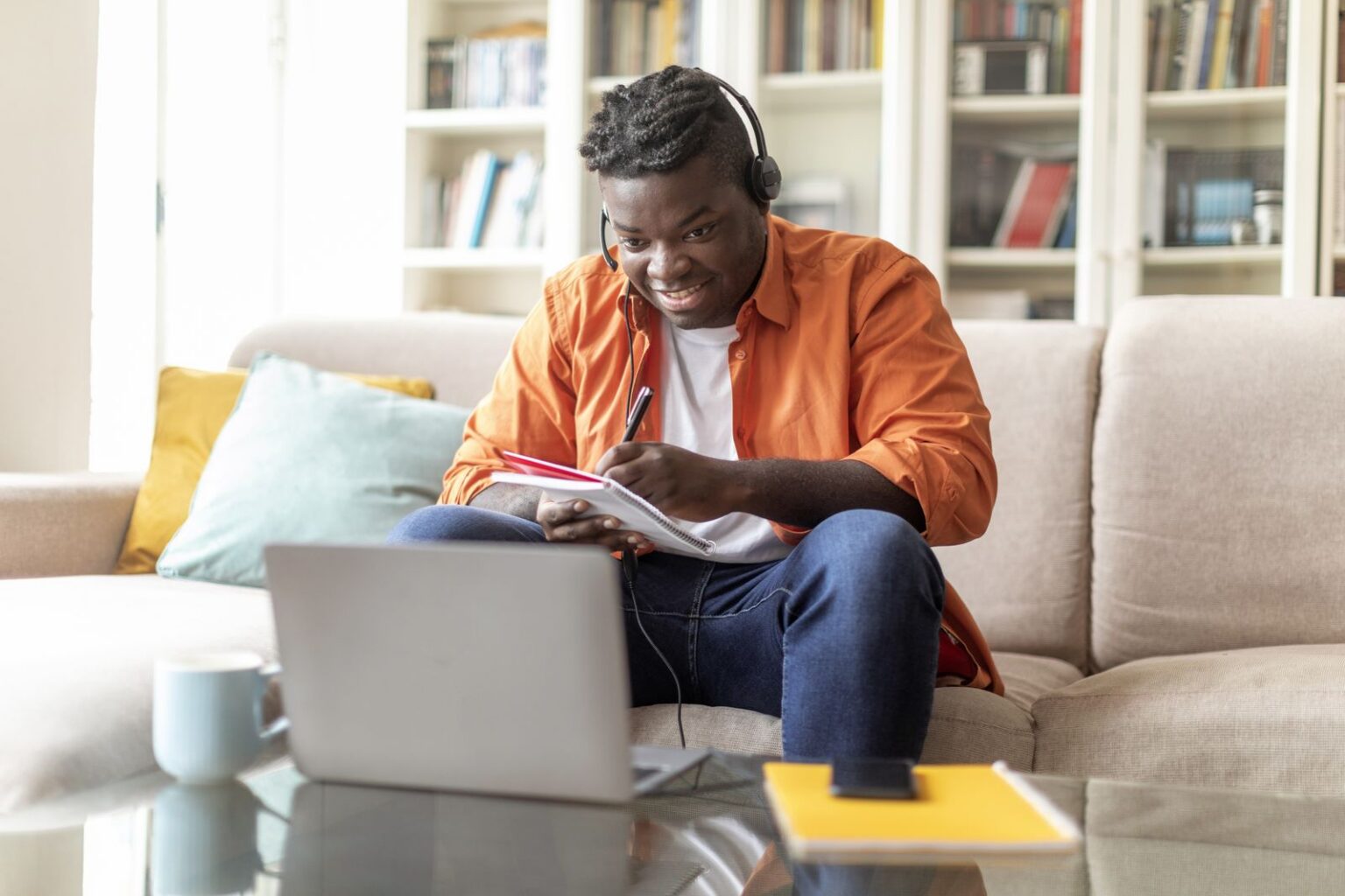 Adult learner taking notes during online ACCUPLACER prep at home
